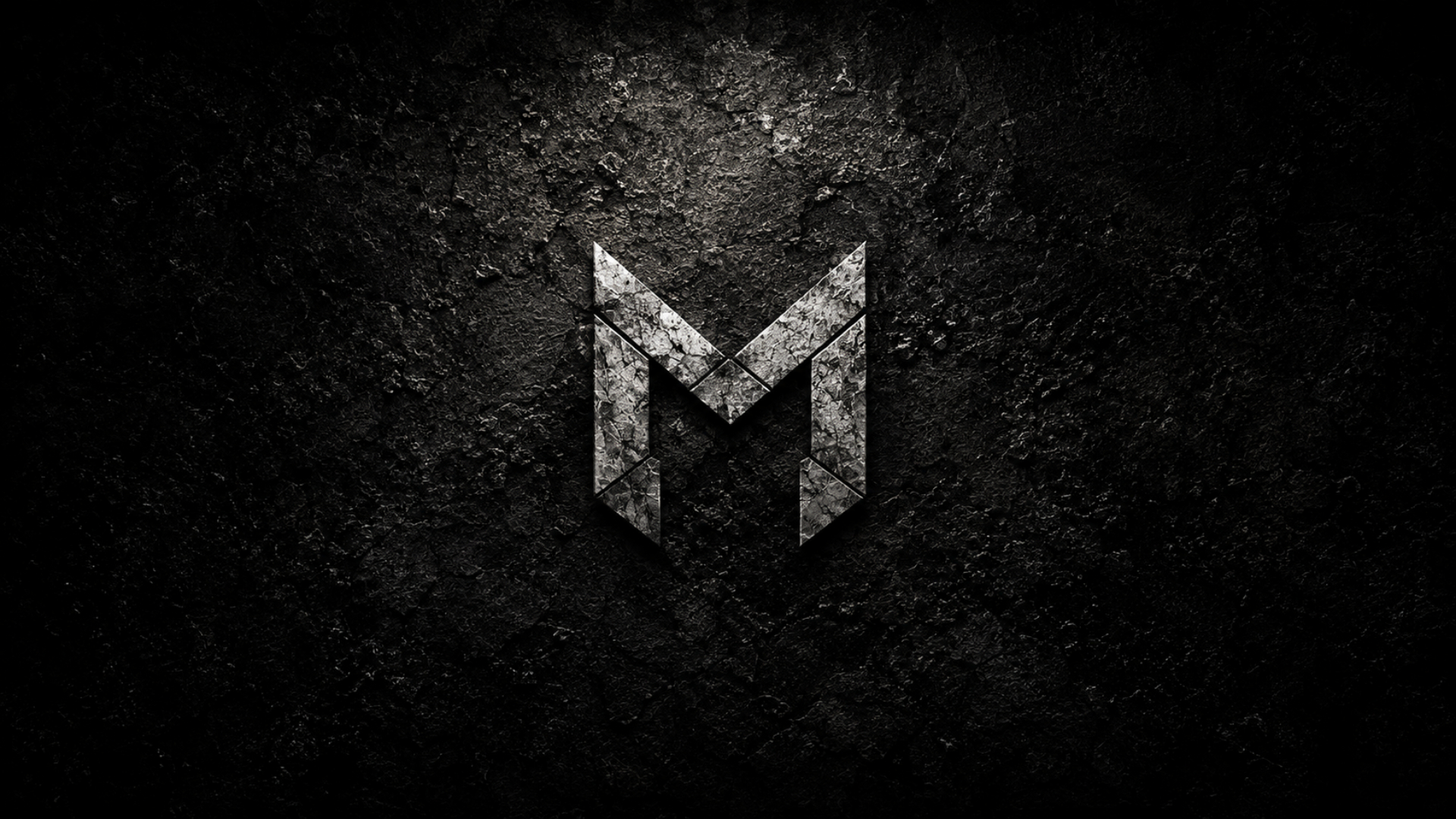 Distressed metallic MHKFT monogram carved into dark concrete